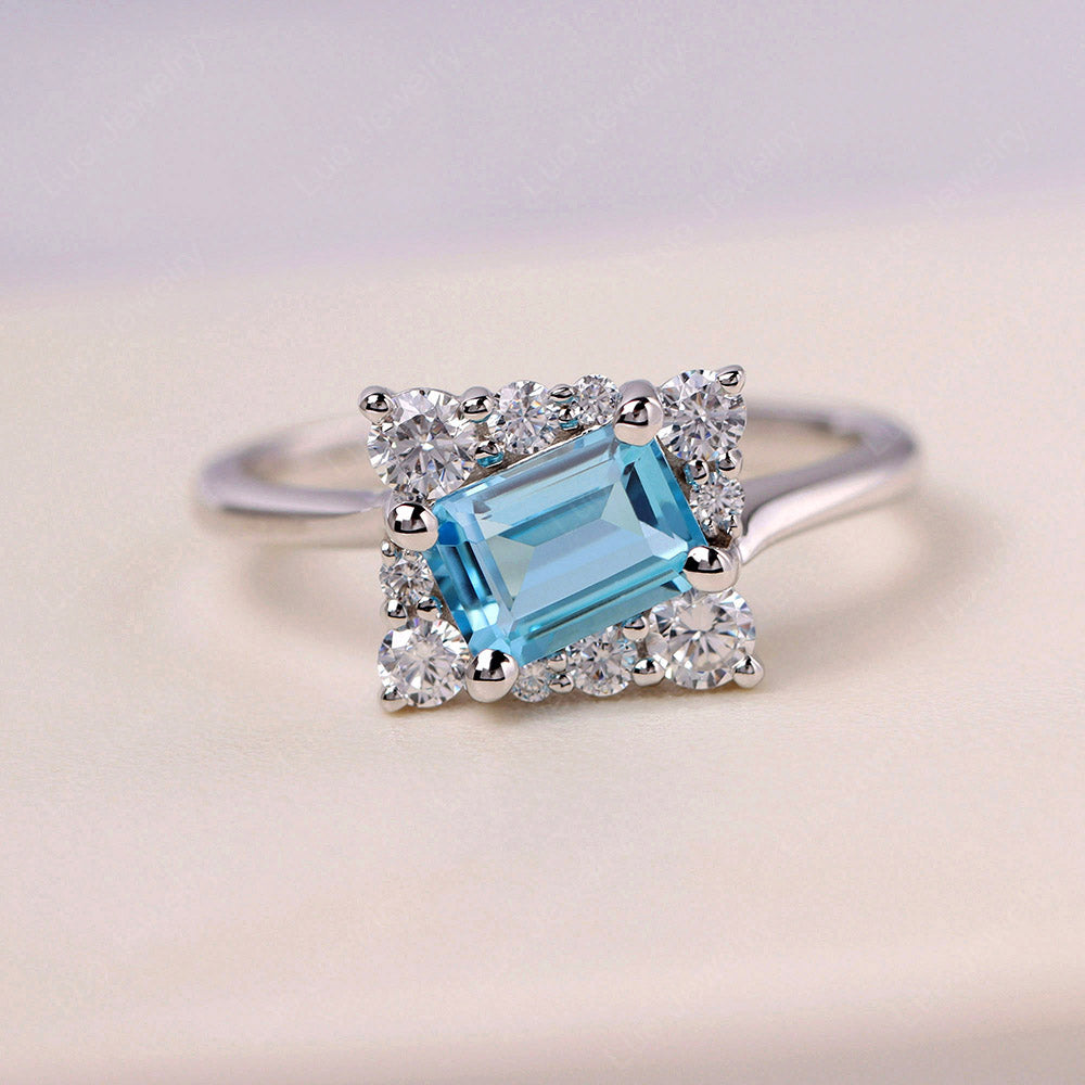 Anillo con halo de topacio azul suizo de talla esmeralda